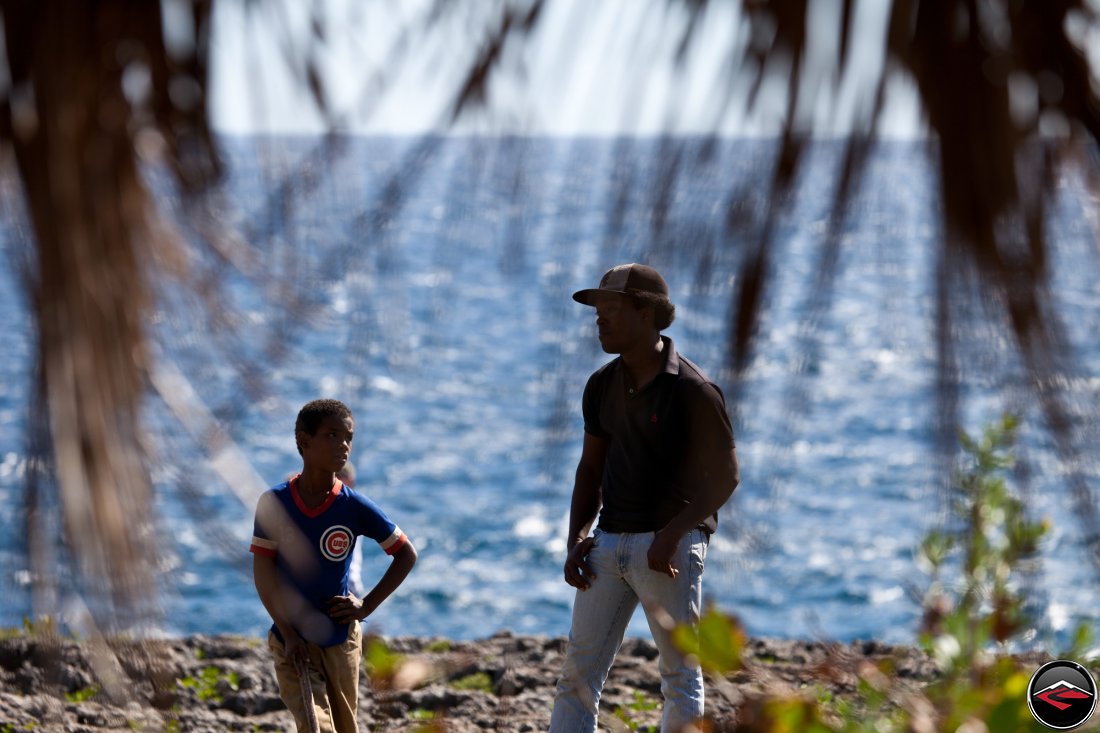 local dominican republic man and boy standing near the ocean