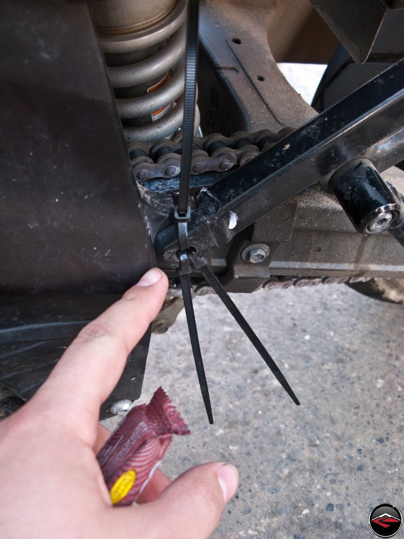 using zip-ties to fix a missing bolt on the subframe of a Suzuki V-strom 650 motorcycle