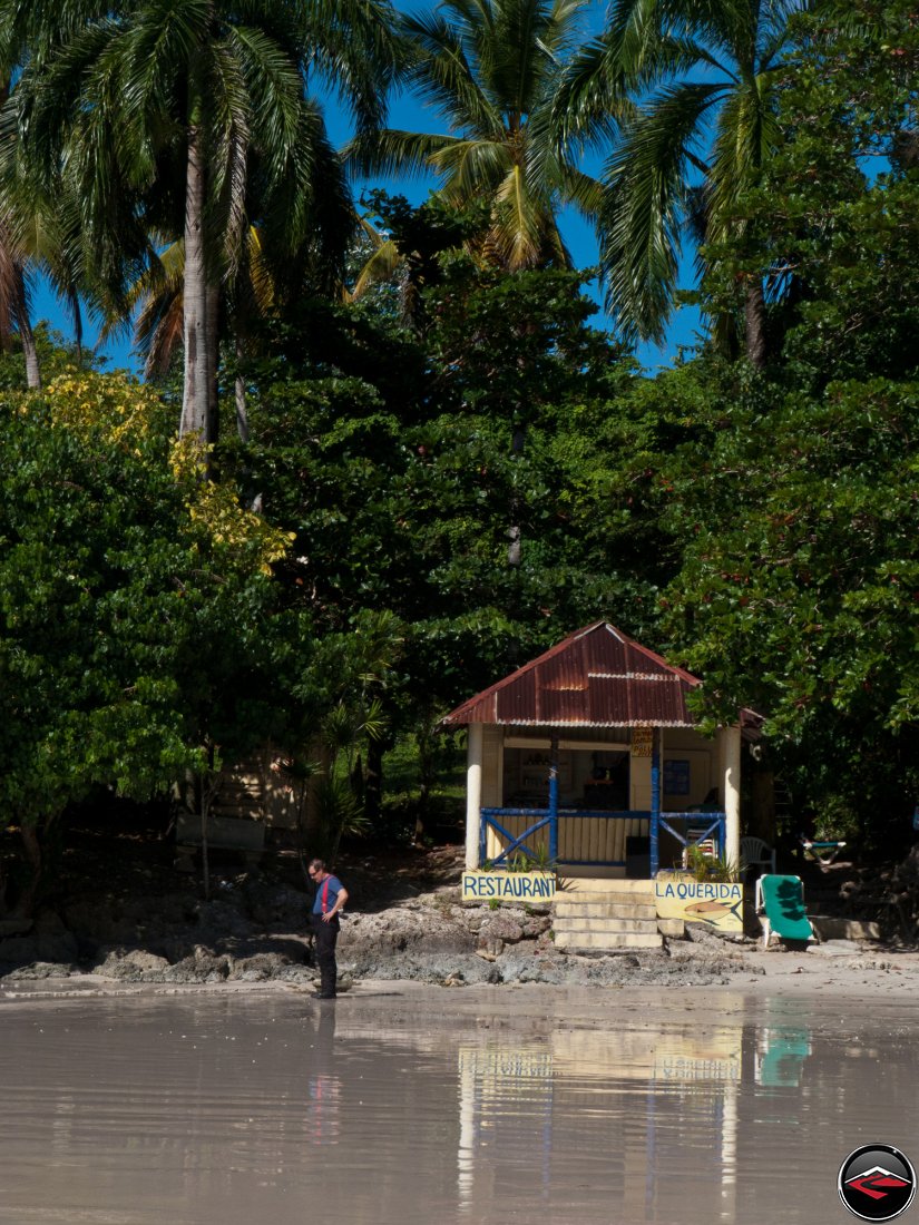 man standing on the beach in front of la querida restaurant in the dominican republic