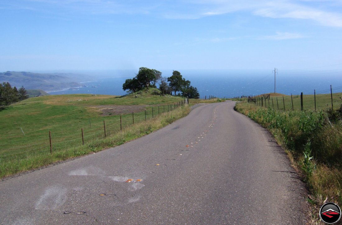 Narrow, windy, Pacific Coast Highway in Northern California with a calm Pacific Ocean in the distance