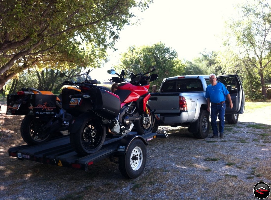 Tom standing next to a Toyota Tacoma with a Ducati Multistrada 1200 and a Buell Ulysses loaded on a 3-Rail Trailer