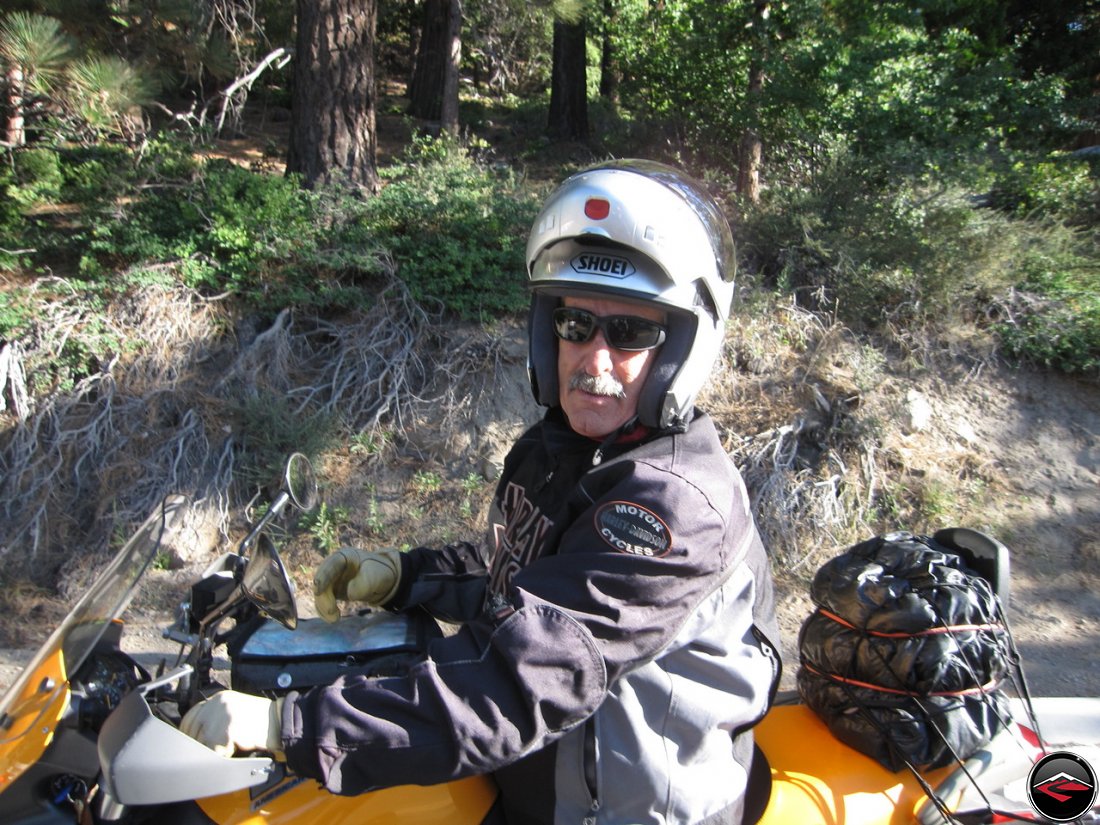 Dad, wearing a flip-face Shoei helmet while riding his Buell Ulysses, asking for directions