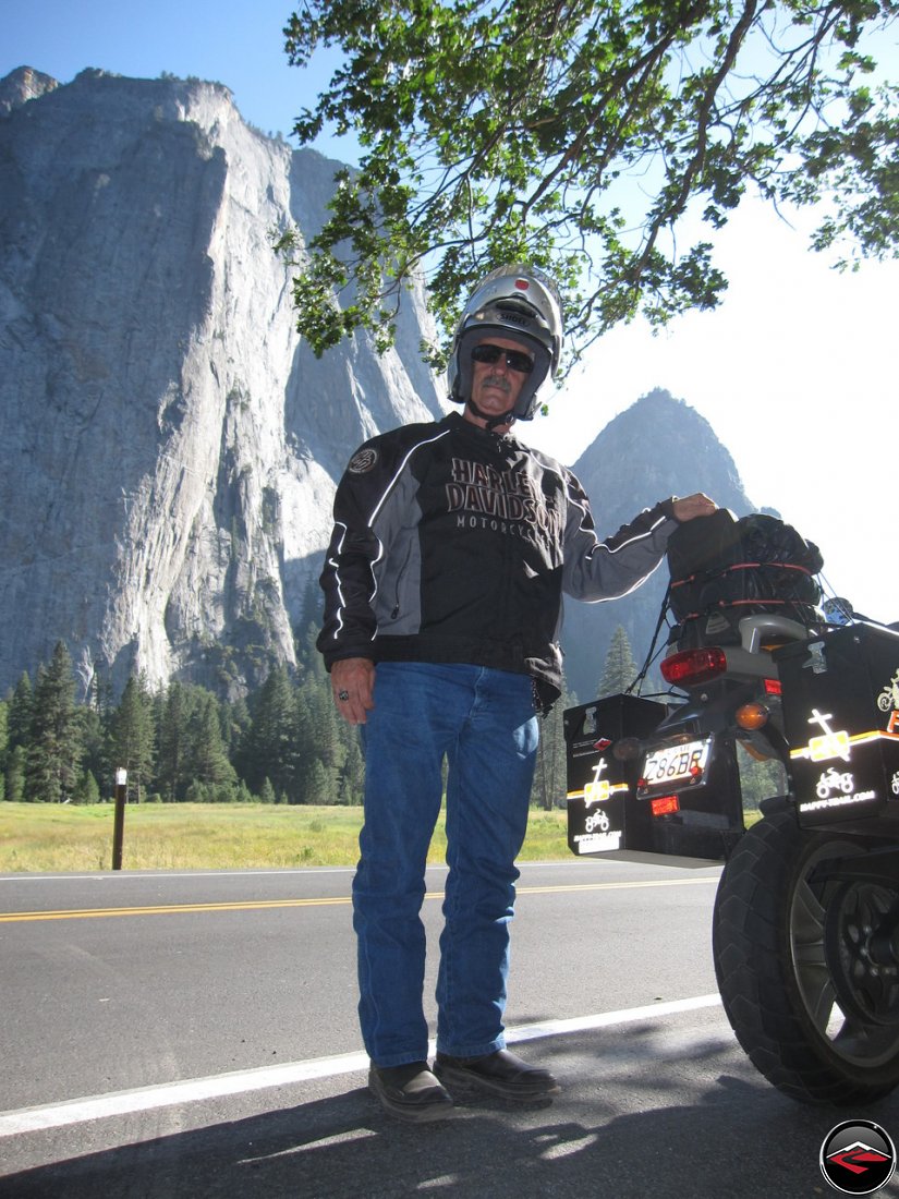 Tom standing next to his Buell Ulysses, fit with Pirelli Sync tires and Happy Trails saddlebags, with El Capitan in the background while visiting California's Yosemite National Park