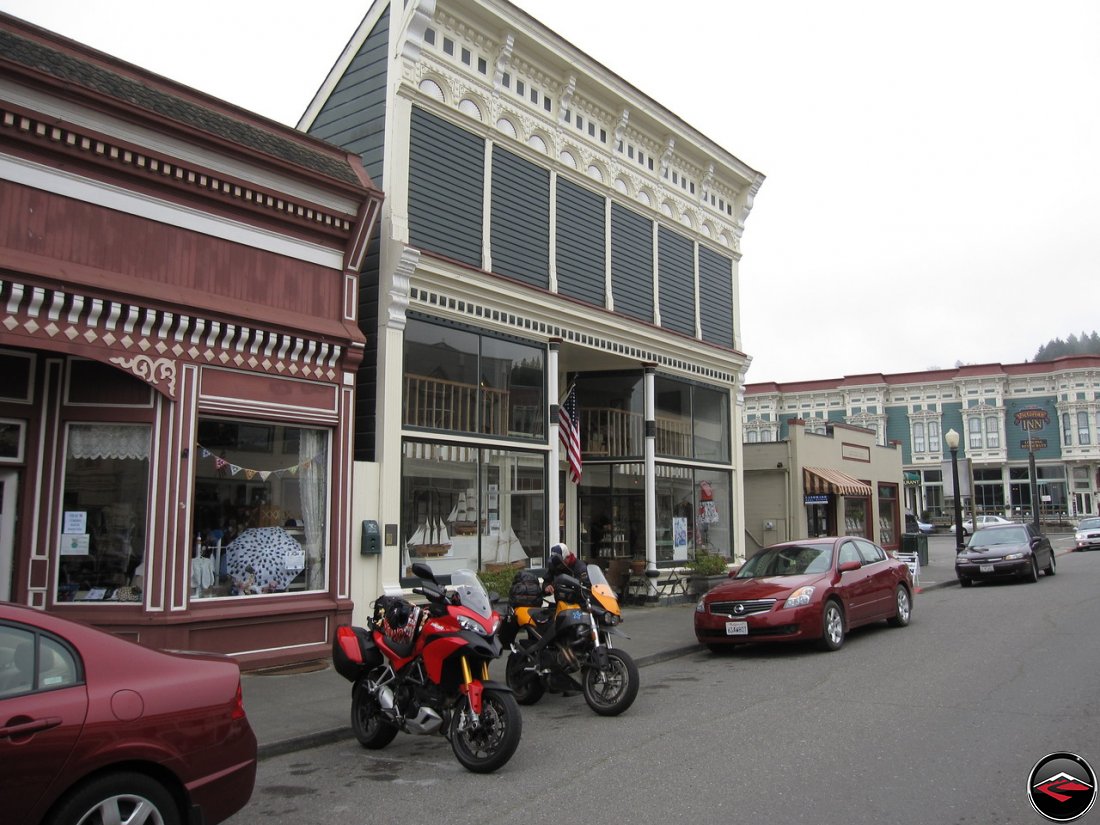 Two motorcycles, a Ducati Multistrada 1200 and a Buell Ulyssess parked on historic main street in Ferndale, California