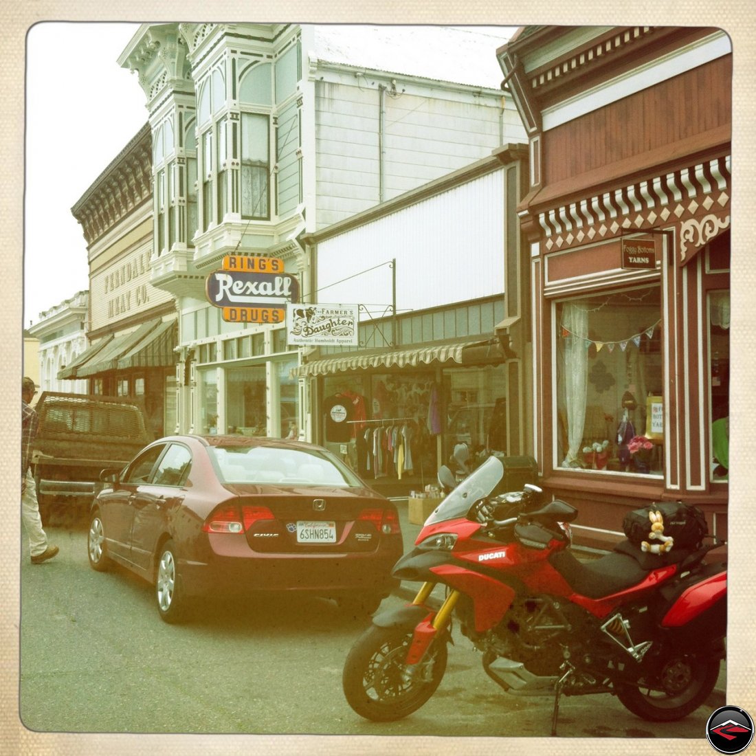 a Ducati Multistrada 1200 parked on historic main street in Ferndale, California, and a sign for Rings Rexall Drugs and Farmers Daughter