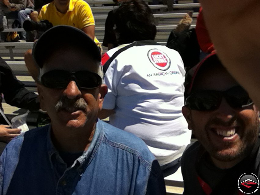 Tom and Dave sitting In the grandstands before the 2012 MotoGP race